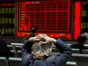 Chinese investors monitor stock prices in a brokerage house in Beijing. More than $2 trillion US in value was wiped off global stock markets.