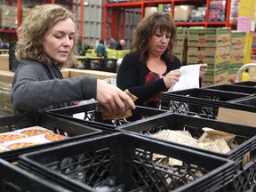 Calgary Food Bank staff Shandra Reynard, left, and Cindy Drummond packed up packages for the Weekends And More (WAM) program on Jan. 19, 2016. The program provides school-aged children with easy to prepare food. WAM is a collaborated effort to meet the needs of students who are food insecure at school or on the weekends.