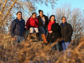 Brenda, second from right, and Dan Lavallee, sit with Harpreet Kharbanda, far right, and her two children, Risham, 9 and Japnoor, 15, along the Bow River on Nov. 28, 2015. The two families suffered major losses when their loved ones Jillian Lavallee and cab driver Amritpal Singh Kharbanda were killed by a drunk driver on May 2, 2015.