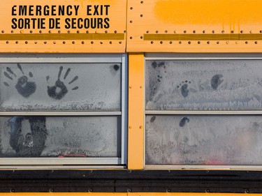 Kids make hand prints in the frost of their school bus windows after leaving the Calgary Zoo on the chilly morning of Jan. 9, 2016.