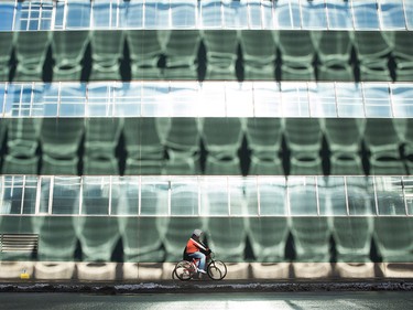 A cyclist passes through light reflections from windows across the street, on Jan. 9, 2016.