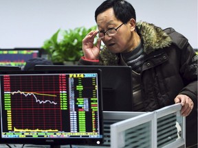 A Chinese investor checks stock prices on a computer terminal in a brokerage house in Jiujiang in central China's Jiangxi province Friday. China's Shanghai stock index sank to its lowest level in more than one year on Friday, as renewed concerns about the world's second-largest economy led global benchmarks lower.