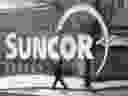 A pedestrian is reflected in a Suncor Energy sign in Calgary. 