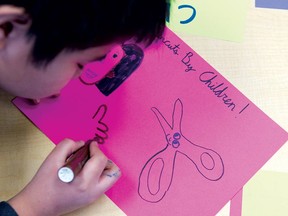 A boy from Abbeydale school prepares a sign for the haircut he and his classmates will give as part of the High Performance Rodeo.