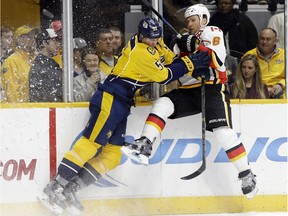 Nashville Predators forward Austin Watson (51) checks Calgary Flames defenseman Dennis Wideman (6) during the second period of an NHL hockey game Tuesday, Dec. 15, 2015, in Nashville, Tenn.