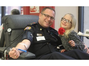 Nick Thain, EMS executive director, gets a rose from eight-year-old Augusta Toews as he gives blood in the Sirens For Life challenge for emergency services personnel on Monday, Jan.  2, 2016 at Canadian Blood Services.