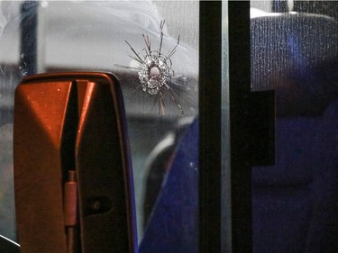 Bullet hole in the driver's side window of a City Transit bus hit by gunfire. Police breach a home nearby after shots were fired toward police at 10 st and 78 ave NW in Calgary, Ab., on Sunday January 24, 2016. Mike Drew/Postmedia Network