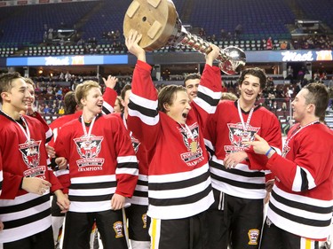 The Calgary Flames Daniel Rybarik holds up the Mac's trophy surrounded by his teammates after winning the Mac's Midget Boy's Championship game at the Scotiabank Saddledome on New Year's Day.