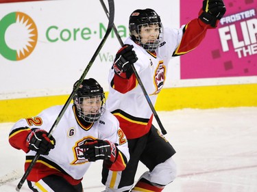 The Calgary Flames'  Julian Benner, left and Tom Mealey celebrate Linden Babcock's game winning goal during the Mac's Midget Boy's Championship game at the Scotiabank Saddledome on New Year's Day.