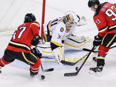 Calgary Flames Michael Frolik and Sam Bennett scramble to score on Nashville Predators goaltender Carter Hutton and tie the game in the closing minutes of the third period of NHL action in Calgary on Wednesday January 27, 2016. Nashville won the game 2-1.