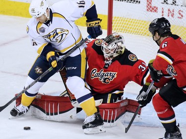 Calgary Flames goaltender Karri Ramo jostles with Nashville Predators  centre Cody Bass during the first period of NHL action at the Scotiabank Saddledome on Wednesday January 27, 2016.