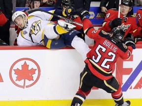 Flames forward Brandon Bollig checks Nashville Predators defenceman Petter Granberg into the Flames bench during the second period at the Scotiabank Saddledome on Wednesday. The Predators won 2-1.