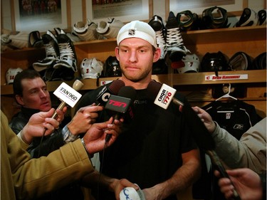 Calgary Flames' Robyn Regehr takes solace while clutching a towel during a news conference following his arrival from 2006 Olympics in Italy.