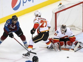 Jarome Iginla #12 of the Colorado Avalanche tries to get off a shot against Dougie Hamilton #27 of the Calgary Flames as goalie Karri Ramo #31 of the Calgary Flames defends the goal at Pepsi Center on January 2, 2016 in Denver, Colorado. The Flames defeated the Avalanche 4-0.