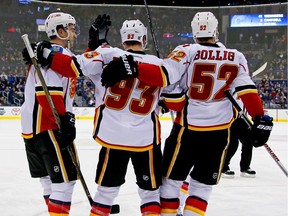 Sam Bennett #93 of the Calgary Flames is congratulated by his teammates after scoring a goal during the third period of the game against the Columbus Blue Jackets.