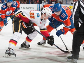Flames centre Sean Monahan, left, squares off against Edmonton's Anton Lander for a faceoff during a game earlier this season. Monahan has improved his percentage to an even 50-50 on the dot.
