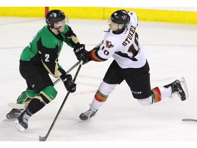 Calgary Hitmen's Jakob Stukel is checked by Prince Albert Raiders' Jesse Lees in WHL action at the Scotiabank Saddledome in Calgary on Friday.