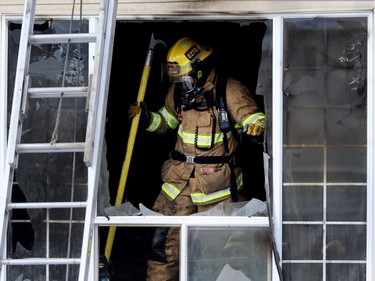 A firefighter works on dousing a house fire at a home on Martinbrook Pl NE on January 13, 2016.