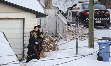 Calgary Police surround a home near where a Calgary Transit bus was hit by gunfire at 10 St. and 78 Ave. NW.