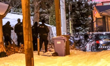 Calgary Police get set to breach a home near where a Calgary Transit bus was hit by gunfire at 10 St. and 78 Ave. NW.