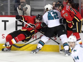 Calgary Flames defenceman Mark Giordano crashed to the ice as he battled San Jose Sharks right winger Joel Ward with the help of Flames left winger Micheal Ferland during third period NHL action at the Scotiabank Saddledome on January 11, 2016. The Sharks defeated the Flames 5-4.