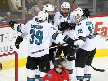 Members of the San Jose Sharks, from left, centre Logan Couture, defenceman Brent Burns, centre Joe Thornton and left winger Patrick Marleau celebrated after scoring against the Calgary Flames during third period NHL action at the Scotiabank Saddledome on January 11, 2016. The Sharks defeated the Flames 5-4.