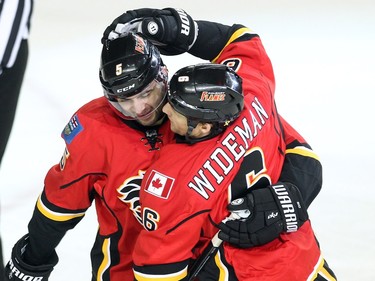 Calgary Flames defencemen Mark Giordano, left, and Dennis Wideman celebrated after Wideman scored the Flames second goal of the game against the San Jose Sharks during second period NHL action at the Scotiabank Saddledome on January 11, 2016.