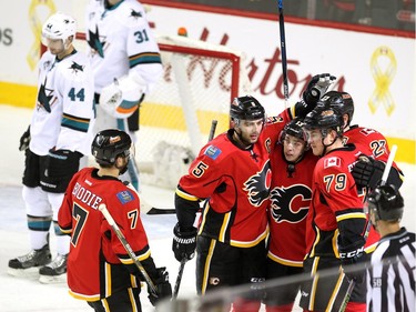 Members of the Calgary Flames, from left, defenceman T.J. Brodie, defenceman Mark Giordano, left winger Johnny Gaudrea, centre Sean Monahan and left winger Micheal Ferland celebrated after Monahan scored against the San Jose Sharks during first period NHL action at the Scotiabank Saddledome on January 11, 2016.