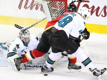 San Jose Sharks goalie Martin Jones reached out to save a shot by Calgary Flames centre Lance Bouma as Sharks centre Tomas Hertl tied him up during first period NHL action at the Scotiabank Saddledome on January 11, 2016.