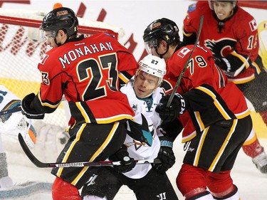 Calgary Flames centre Sean Monahan, left, and left winger Micheal Ferland crunched San Jose Sharks right winger Joonas Donskoi deep in the Sharks zone during first period NHL action at the Scotiabank Saddledome on January 11, 2016.