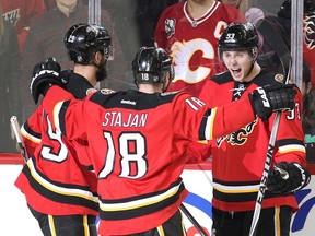 Calgary Flames players, from left, defenceman Deryk Engelland and centre Matt Stajan celebrate with centre Sam Bennett after he scored his third goal of the game against the Florida Panthers. Bennett, who became the youngest player in Flames history to score a hat-trick, added a fourth goal in the game's final minute.