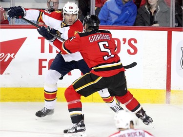 Calgary Flames defenceman Mark Giordano checked Florida Panthers veteran player right winger Jaromir Jagr during first period  NHL action at the Scotiabank Saddledome on January 13, 2016.