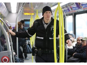 Calgary Transit Peace Officer Leggett makes his way down a CTrain car leaving the downtown free-fare zone on the lookout for riders who haven't paid.
