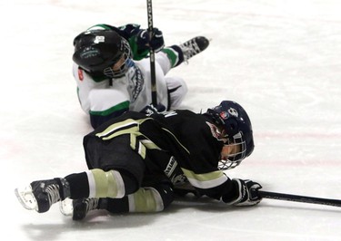 One of the Springbank Rockies N7 Blue players lands on Quinn Wilson from the Crowfoot Sharks N7 as the Springbank Rockies win with a 4-1 lead during a Novice North Esso Minor Hockey Week at Shouldice Arena, on January 16, 2016. (Christina Ryan/Calgary Herald)