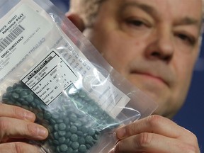 Calgary police Staff Sergeant Brad Moore holds up a bag of fentanyl pills Tuesday, Jan. 26, 2016 at police headquarters.