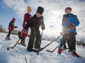 FILE PHOTO: Spencer Perron, centre, grabs for a puck sent off ice at McKenzie Lake in Calgary on Sunday, Jan. 24, 2016. Over 350 Calgarians gathered to skate and play hockey in memory of Jordan Feradi and to raise money for the Canadian Children's Brain Cancer Foundation.