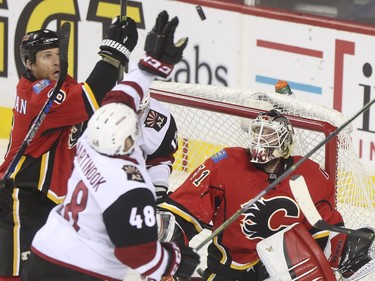Calgary Flames goalie Karri Ramo and Dennis Wideman watch as Arizona Coyotes Jordan Martinook reaches for a loose puck in front of the net during game action at the Scotiabank Saddledome in Calgary, on January 7, 2016.