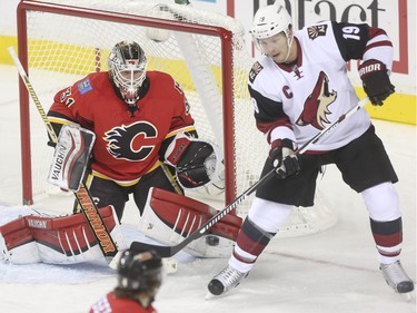 Arizona Coyotes Shane Doan tries to knock the puck past Calgary Flames goalie Karri Ramo during game action at the Scotiabank Saddledome in Calgary, on January 7, 2016.