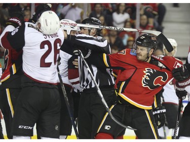 Calgary Flames Lance Bouma gets pulled away from a scuffle in front of the Coyotes net as he reaches for Arizona's Michael Stone during game action at the Scotiabank Saddledome in Calgary, on January 7, 2016.