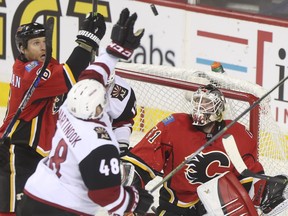 Calgary Flames goalie Karri Ramo and Dennis Wideman watch as Arizona Coyotes Jordan Martinook reaches for a loose puck in front of the net during game action at the Scotiabank Saddledome on Thursday. Ramo played well but the Flames came up short, falling 2-1.