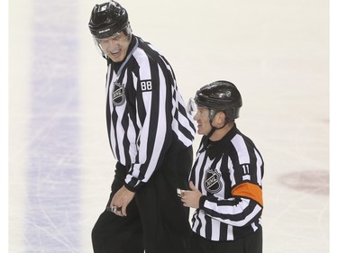 Linesman Mike Cvik, left, laughs with referee Kelly Sutherland during his last NHL career hockey at the Saddledome in Calgary, on January 5, 2016. Cvik retires after tonights match up between the Calgary Flames and the Tampa Bay Lightning.