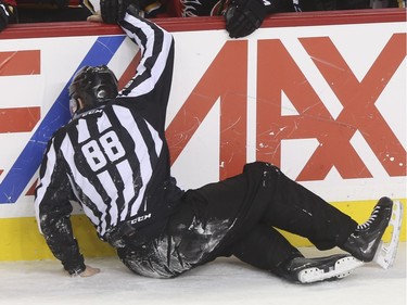 Linesman Mike Cvik takes a nasty spill during his last NHL career hockey at the Saddledome in Calgary, on January 5, 2016. Cvik retires after tonights match up between the Calgary Flames and the Tampa Bay Lightning.