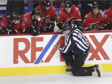 The Calgary Flames help up linesman Mike Cvik after he takes a nasty spill during his last NHL career hockey at the Saddledome in Calgary, on January 5, 2016. Cvik retires after tonights match up between the Calgary Flames and the Tampa Bay Lightning.