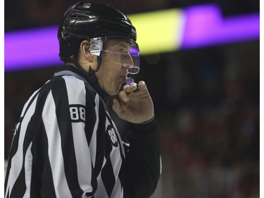 Linesman Mike Cvik blows his whistle during his last NHL career hockey at the Saddledome in Calgary, on January 5, 2016. Cvik retires after tonights match up between the Calgary Flames and the Tampa Bay Lightning.