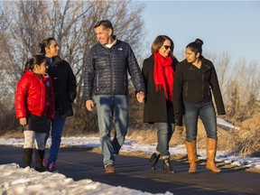 Brenda and Dan Lavallee, centre, with Harpreet Kharbanda and her two children, Risham, 9 and Japnoor, 15, stroll along the Bow River on Nov. 28, 2015. The two families bonded over the deaths of Jillian Lavallee and Amritpal Singh Kharbanda.