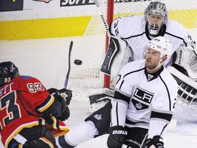 Calgary Flames centre Sam Bennett gets a shot off on the The Los Angeles Kings' Jonathan Quick as Alec Martinez tries to block during NHL action at the Scotiabank Saddledome on New Year's Eve December 31, 2015.