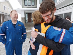 With STARS pilot Greg Chorney looking on, STARS flight nurse Pat Jeffery hugs patient Andre Van Driesten after the two realized she had been the flight nurse on the STARS mission that had helped save Andre's life. Andre's heart stopped in 2013 while he was driving near Fort Macleod. Both Andre and Pat were part of the launch for the 2016 STARS lottery. (Gavin Young/Calgary Herald) (For City section story by Claire Young) Trax# 00071153A