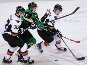Calgary Hitmen Travis Sanheim, left, and Jake Virtanen box in the Prince Albert Raiders' Matteo Gennaro during a game last January. On Sunday, the Hitmen acquired Gennaro in a trade with the Prince Albert Raiders. He will meet up with the team on Monday, the same day Sanheim returns to the club from the World Juniors.