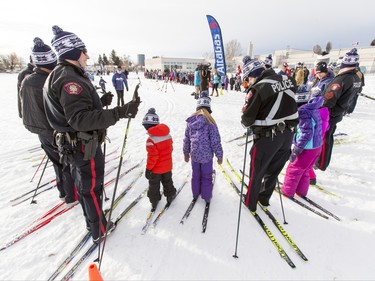 Police officers stand with kids on cross-country skis at Mount View School in Calgary, Alta., on Tuesday, Jan. 26, 2016. The Calgary Fire Department and Calgary Police Service, along with a pair of Olympians, went head-to-head in a relay race for an announcement by AltaGas to support Cross Country Ski de Fond Canada's Ski at School program for the next three years. Lyle Aspinall/Postmedia Network