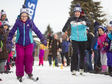 Olympic silver medallist Sara Renner watches her young competition during a cross-country ski relay race at Mount View School in Calgary, Alta., on Tuesday, Jan. 26, 2016. The Calgary Fire Department and Calgary Police Service, along with a pair of Olympians, went head-to-head in a relay race for an announcement by AltaGas to support Cross Country Ski de Fond Canada's Ski at School program for the next three years. Lyle Aspinall/Postmedia Network